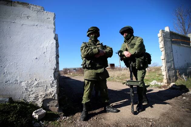 ITAR-TASS: CRIMEA, UKRAINE. MARCH 3, 2014. Masked servicemen stand in a street of Perevalnoe village in the Autonomous Republic of Crimea, where the 36th separate brigade of the Ukrainian Navy coastal defence is stationed.  RE13B878