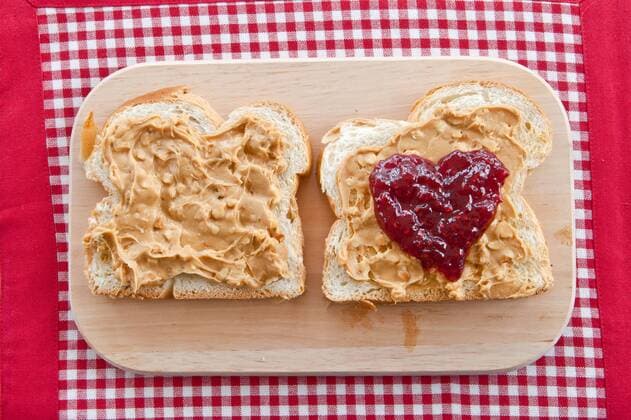 Eine Scheibe Brioche mit Erdnussbutter und Marmelade  1079700831