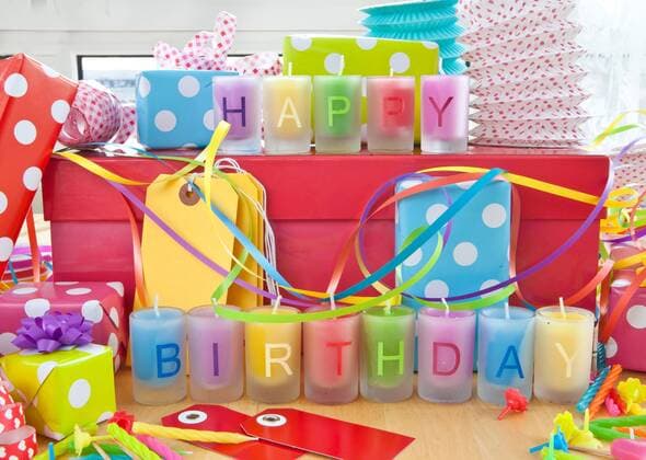 Geburtstag - Symbolbilder Happy Birthday geschrieben auf bunten Kerzen und Geschenke  1079700787