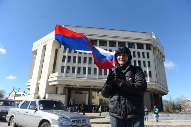 (140317) -- SIMFEROPOL, March 17, 2014 (Xinhua) -- A man waves a national flag of Russia in front of the local parliament in the Crimean capital of Simferopol, Ukraine, March 17, 2014. The Crimean parliament declared independence from Ukraine on Monday, after official results showed 96.77 percent of Crimean voters chose to join Russia in Sunday s referendum. (Xinhua Sadat) (djj) UKRAINE-CRIMEA-INDEPENDENCE 