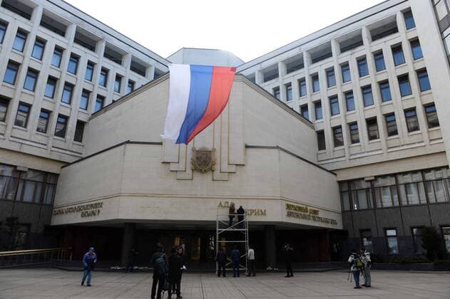 (140318) -- SIMFEROPOL, March 18, 2014 (Xinhua) -- Workers dismantle the Ukrainian signs on Crimean Parliament building in Simferopol, the Republic of Crimea, March 18, 2014. Russian President Vladimir Putin and leaders of Crimea signed a treaty on Tuesday accepting the Republic of Crimea and the city of Sevastopol as part of the Russian territory. (Xinhua Sadat) (srb) CRIMEA-SIMFEROPOL-RUSSIA-TREATY 