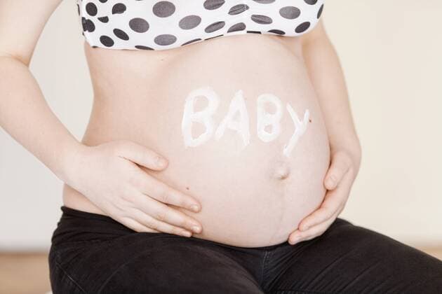 Schwangere Frau sitzt und hält sich den Bauch, Creme, Babybauch, werdende Mutter, Schwangerschaft, Geschenk, Überraschung, feminin, herz, Namen, Mira, Namensfindung,  1064200304