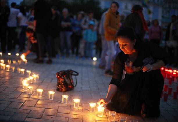 ITAR-TASS: KIEV, UKRAINE. MAY 17, 2014. A woman lights a candle at a Light a spark in your heart ceremony to mourn the victims of the Crimean Tatar deportation, in St. Michael s Square.  RE1442EF