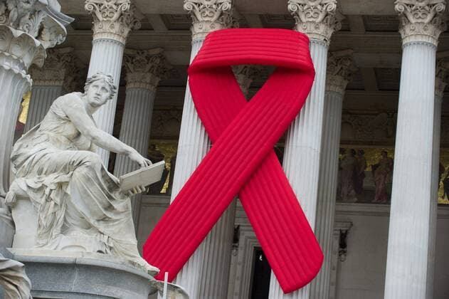 THEMENBILD - Rote Schleife am Parlament. Die Rote Schleife ist das Symbol zur Solidarität fuer HIV Infizierte und AIDS Kranke. Das Bild wurde am 28. Mai 2014 aufgenommen. im Bild Rote Schleife am Haupttor des österreichischen Parlaments THEMES PICTURE - Red Ribbon on Austrian Parliament. The Red Ribbon is the symbol for solidarity of people living with HIV AIDS. The image was taken on may, 28th, 2014. Picture shows Red Ribbon on main gate of the Austrian Parliament, AUT,  EP_Gru 