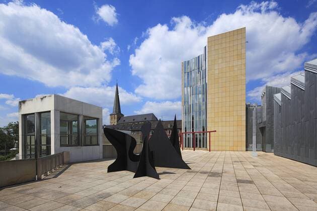 Architektur von Hans Hollein Staedtisches Museum Abteiberg mit Skulptur von Alexander Calder und City-Kirche in Moenchengladbach, Niederrhein, Nordrhein-Westfalen D-Moenchengladbach, Niers, Niederrhein, Rheinland, Nordrhein-Westfalen, NRW, Staedtisches Museum Abteiberg, Museumsneubau von Hans Hollein, Museum fuer Bildende Kunst, Skulptur von Alexander Calder, dahinter die Citykirche, ehemals St. Maria Himmelfahrt, katholische Kirche, D-Moenchengladbach, Niers, Lower Rhine, Rhineland, North Rhine-Westphalia, NRW, Museum Abteiberg, new building by Hans Hollein, art museum, sculpture of Alexander Calder, behind the City Church, former Saint Maria Himmelfahrt, catholic church