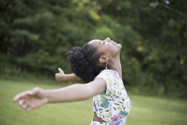 IMAGO Creative: Landleben, Mit Nachhaltigkeit grün auf dem Land leben A young woman in a summer dress with her arms outstretched, celebrating freedom. 