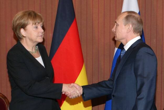 ITAR-TASS: DEAUVILLE, FRANCE. JUNE 6, 2014. German Chancellor Angela Merkel (L) and Russian President Vladimir Putin shake hands during a meeting at Normandy Barriere hotel in Deauville.  RE1465FA