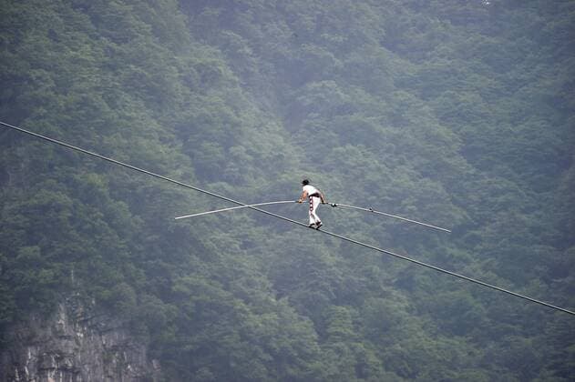 ZHANGJIAJIE, CHINA - JUNE 28: (CHINA OUT) Freddy Nock, known as Europe s King of the High Wire , walks on the Tianmen Mountain Cableway without any protective measures on June 28, 2014 in Zhangjiajie, Hunan Province of China. Freddy Nock, who is a world record holder of various events and known as Europe s King of the High Wire , once again took on the challenge of walking on Asia s longest and most dangerous cable, the Tianmen Mountain Cableway, without any protective measures. After walking 420 m, he gave up because the slope was too steep and his feet were too slippery. In 2010, Nock did the same challenge at Tianmen Mountain Cableway. He walked for about 200 m before giving up due to severe rolling and shaking of the cable beneath his feet.  CFPpremiumd 0460