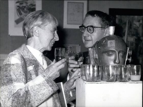 Sep. 09, 1958 - Dada-Exhibition in D&uuml;sseldorf The greatest Dada-Exhibition in Germany after the war begins on Friday, Sept. 5th in the nail of Arts in D&uuml;sseldorf. OPS: Man Ray from New York and Hanna Hoech from Berlin during the press-reception. They have a drink at the exhibition-piece No. 398 the mechanic head  - ZUMAk09