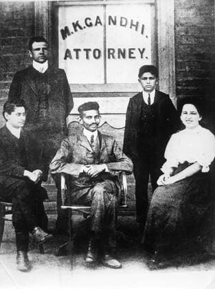 IMAGO ICONS: Mahatma Gandhi Nov. 13, 1903 - De Aar, South Africa - MAHATMA GANDHI (1869-1948) (center), his long term friend H.S.L. POLAK (sitting left) and Gandhi s secretary Miss SCHLESIN (right) pictured in South Africa, in conventional European clothing while he was practising as an attorney. Where Gandhi first employed his ideas of peaceful civil disobedience in the Indian community s struggle for civil rights. De Aar South Africa  - ZUMAk09