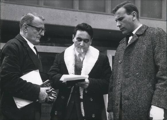 Dec. 12, 1964 - Escapee from Auschwitz testifies in Frankfurt trials The biochemist dr. Rudolf VRA,, born in Slovakia and now living in London, appeared before the grand jury in Frankfurt, Germany, to the testify against the accused former SS-guards of the Auschwitz extermination camp and the former Eichmann - aides Hunsc~e and Krumey, who are facing the court in a separate trial Dr. Vrba, 40, a jew with the birth name Rosenberg, Changes his name after he had managed to escape from Auschwitz in April 1944, Where he was held as prisoner facing death in the terrible gas chambers. After his hearing Dr. Vrbba told his story to a policemen and to some unidentified spectator of the trial.  - ZUMAk09