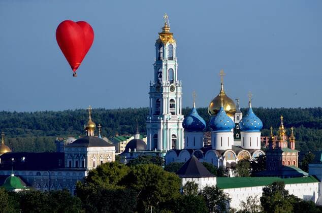 ITAR-TASS: MOSCOW REGION, RUSSIA. JULY 19, 2014. A heart-shaped manned balloon flies over the Holy Trinity Lavra (monastery) during a hot-air balloon festival Saint Sergius Sky in Sergieyev Posad outside Moscow. It was held to mark the 700th birth anniversary of Russian saint, Sergius of Radonezh, the monastery s founder.  Aufmacher premiumd 5876