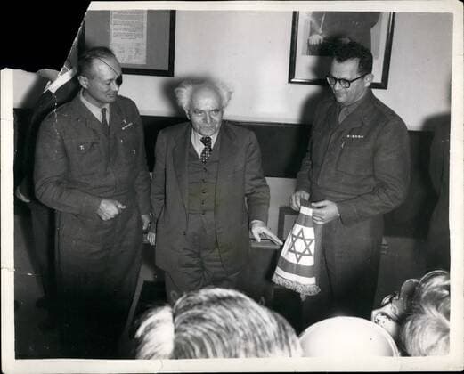 Feb. 02, 1958 - Israel has new Chief of Staff. : Mr. Ben Gurion, the Israel Prime MInister, announced the appointment in Jerusalem on Thursday of General Chaim Laskov, as the new Chief of Staff - at a ceremony in the Premier s office, after General Moshe Dayan, Chief of Staff of the Israel defence force since 1953, formally relinquished hi command. Photo shows Mr. Ben-Gurion (centre), with General Moshe Dayan (left), and the new Chief of Staff, General Chaim Laskov, who is holing the flag of the Chief of Staff - at the ceremony in Jerusalem.  - ZUMAk09