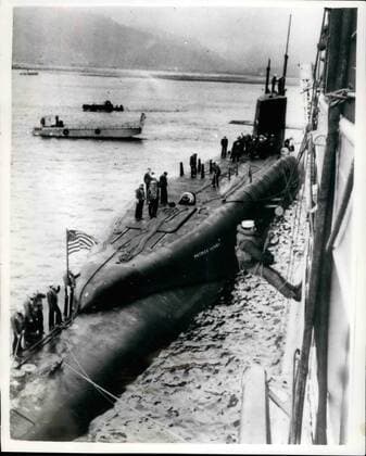 Mar. 03, 1961 - Polaris Submarine Arrives In Holy Loch: The 6700-ton American Polaris submarine Patrick Henry arrived in the Holy Loch, Firth of Clyde, today, and tied up alongside the submarine depot ship Porteus . Photo shows An American sailor is lowered from the side of the depot ship Proteus to help with the Polaris submarine s mooring in the Holy Loch today.  - ZUMAk09