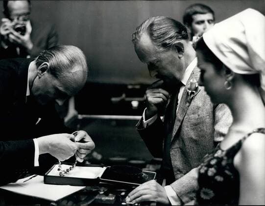 Jun. 16, 1966 - 16-6-66 Lady Pamela Hicks sells the famous Mountbatten emerald necklace for &pound;42,000 Ã¢â‚¬âÄœ Lady Pamela Hicks, wife of interior decorator David Hicks, today sold the famous Mountbatten emerald necklace which was left to her by her mother, Lady Mountbatten. It went up for auction at Sotheby s in London, and was bought by Mr. M.A. Seymour for &pound;42,000. The necklace, which was made in Paris, consists of nine magnificent emeralds arranged as drops from a diamond collar. The three centre emeralds alone weigh nearly 50 carats. Photo Shows: Mr. Llewellyn, the auctioneer, (left) has trouble with the elapse of the necklace watched by the buyer Mr. M.A. Seymour, and his 19-year old daughter Caroline, who was anxious to try it on.  - ZUMAk09
