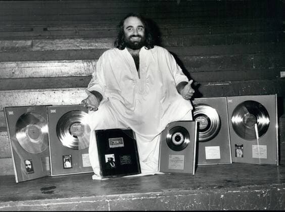 Oct. 10, 1976 - International singing star Demis Roussos is presented with Gold and Silver awards at the Royal Albert Hall: International singing star, Demis Roussos, was last night awarded a silver disc for his L. P. Fire and Ice , denoting U. K. sales exceeding ?100,000: gold discs for his L. P. s Happy to be , My only Fascination and Souvenirs , denoting U. K. sales exceeding ?250,000; also a siver disc for exceeding 250,000 copies; plus a gold cassette for Forever and ever , the album of which has been gold in the U. K. for over a year. The awards were presented to Demis at the end of his 3rd sell-out concert at the Royal Albert hall last night. Photo shows Demis Roussos pictured with his award at the Royal Albert Hall last night.  - ZUMAk09