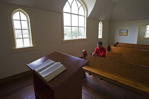 Middle age male praying in United church, Dorothy, Alberta, Canada.  acp74649 Photography