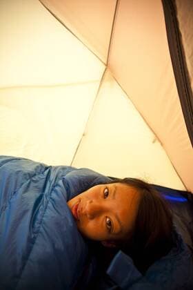 A young woman wakes up while camping in Jasper Provincial Park, Alberta, Canada  acp49206