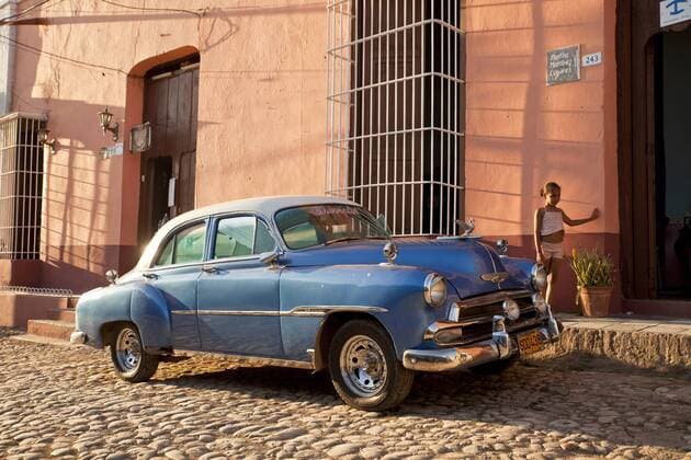 Cuba, Us car on cobblestone street  PC000014