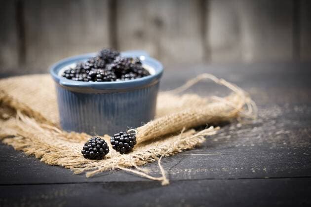 Bowl of blackberries, Rubus sectio Rubus, on jute and dark wood  MAEF008820