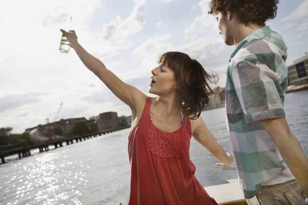 Germany, Berlin, Young couple on motor boat, woman dancing model released  VVF00061