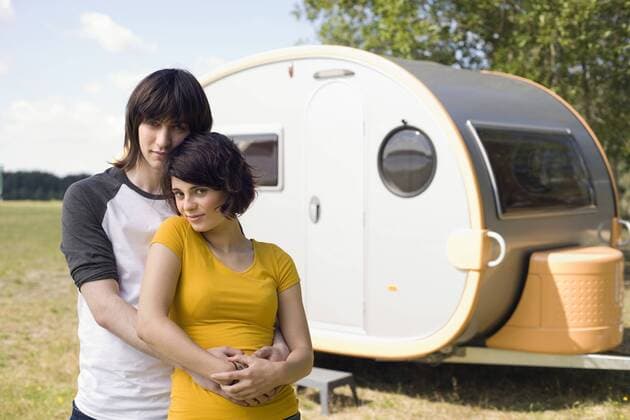 Germany, Leipzig, Ammelshainer See, Young couple embracing, in background camping trailer, portrait model released property released  WESTF09406