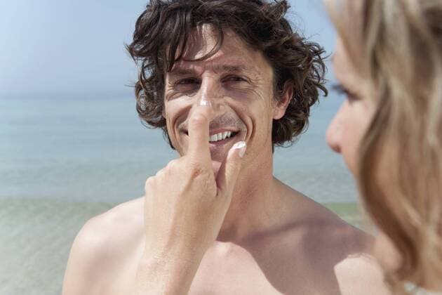 IMAGO Creative, Jahreszeit Sommer, Sonnenschutz Spain, Mallorca, Woman applying suncream on man s nose model released  WESTF12688