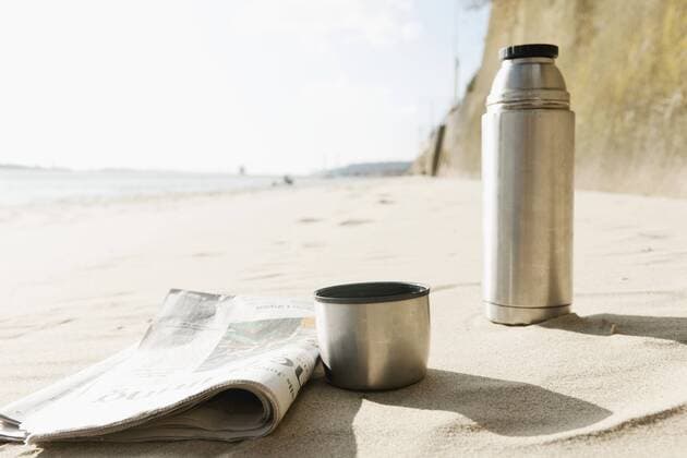 Germany, Hamburg, Close up of newspaper and thermos flask at beach near Elbe riverside model released  DBF000120