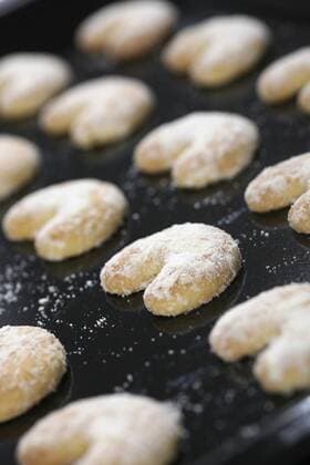 Row of vanilla crescent cookies in baking tray  KNF000638