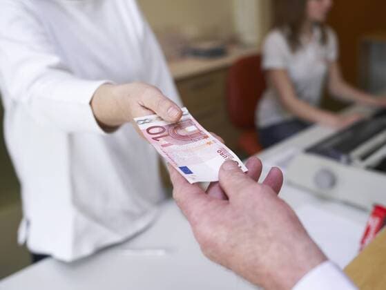 Germany, Hamburg, Woman receiving cash from senior man model released property released  KNF001136