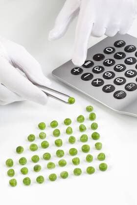 Man holding pea in tweezer while using calculator model released  MAEF002960