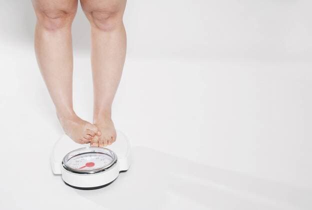 Young woman standing on bathroom scales model released property released  PDF000141