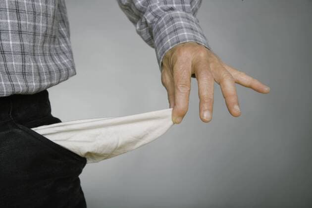 Close up of mature man holding empty pockets against grey background model released  TCF001577