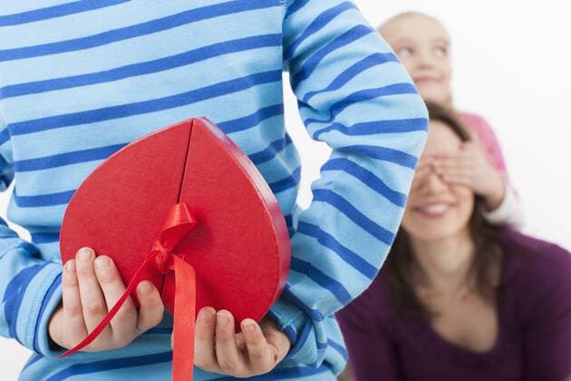 Daughter covering eyes of mother, Son with gift box in foreground model released  BMYF000162