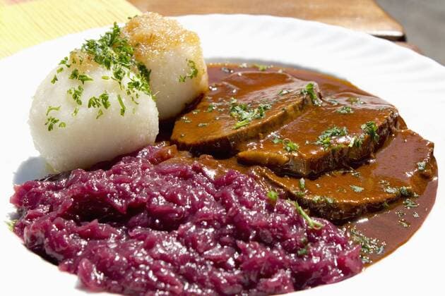 Plate of sauerbraten marinated beef with red cabbage and potato dumpling  CSF017821