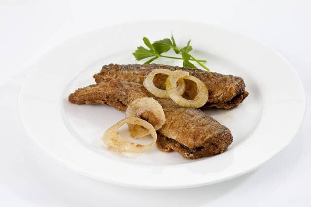 Fried herring with onions and vinegar on plate, close up  CSF018711