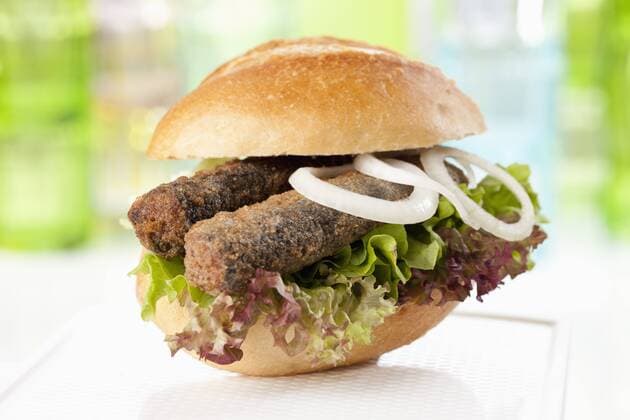 Bread roll with fried herring and onions, close up  CSF018731