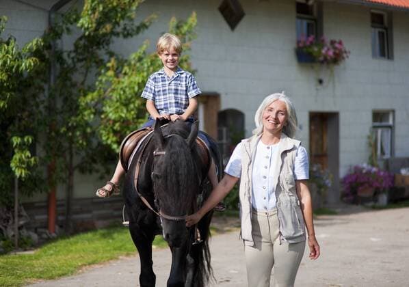 Germany, Bavaria, Mature woman leading boy on horse model released property released  HSIYF000074