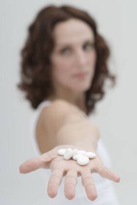 Mid adult woman showing white pills in hand model released  KPF000388