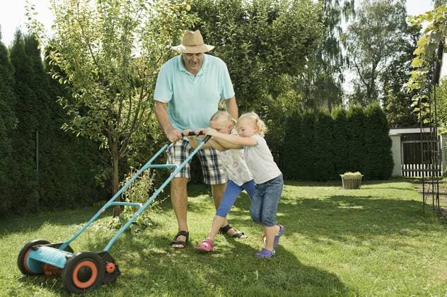 Germany, Bavaria, Grandfather with children mowing lawn model released property released  RNF001004