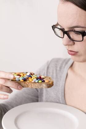 Young woman holding bread garnished with lots of tablets model released  DRF000320
