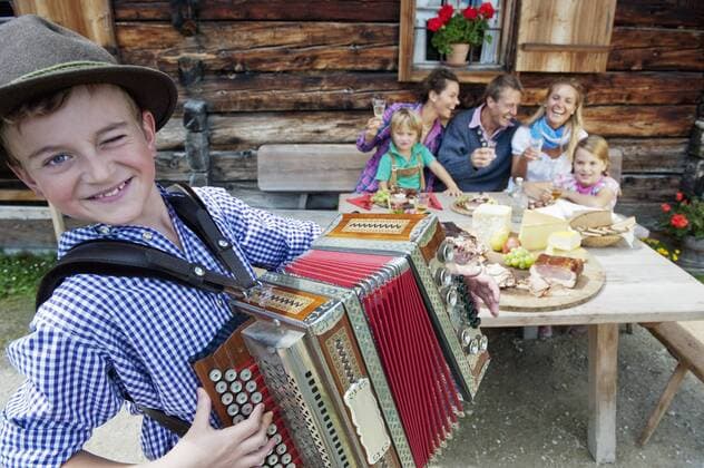 Austria, Salzburg State, Altenmarkt-Zauchensee, family having an alpine picnic while young boy playing accordion model released property released  HHF004721