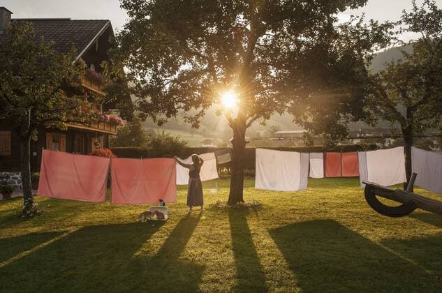 IMAGO Creative: Landleben - Alfresco, Draußen Austria, Radstadt, Farm, Female farmer hangs the washing on the line model released property released  HHF004779