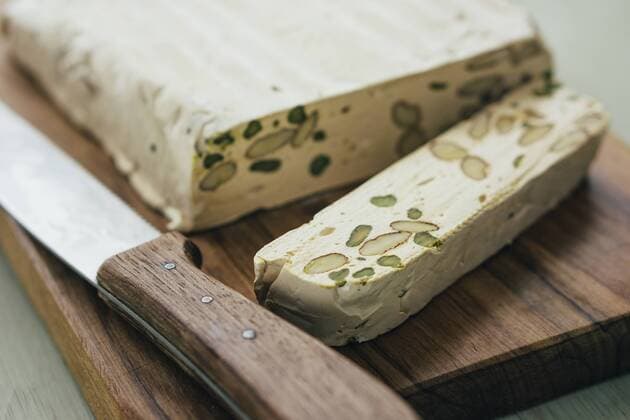 Sliced home-made turron with pistachios and almonds on wooden board  IPF000140