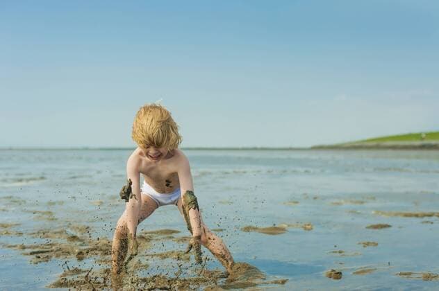 IMAGO Creative: Ruhe im Chaos Germany, Schleswig Holstein, Boy playing in mud at beach model released  MJF000222