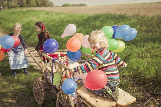 Three children on the move with wooden trolley and balloons model released  MJF001155