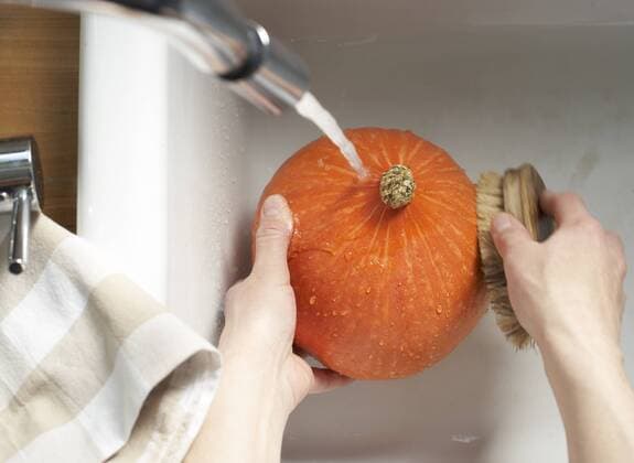 Hands of woman cleaning Hokkaido pumpkin with vegetable brush in sink, elevated view model released  SABF000025