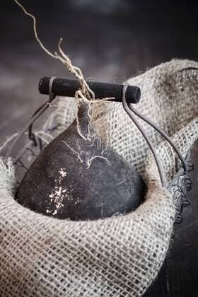 Black radish (Raphanus sativus) in wire basket with rug, studio shot  SBDF000249