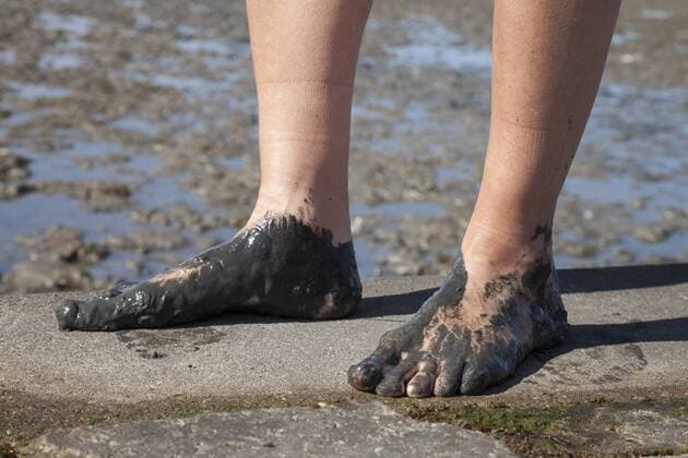 Germany, Lower Saxony, Nessmersiel, woman s feet covering with mud model released  WIF000862