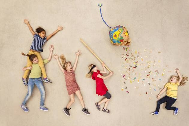Geburtstag - Symbolbilder Children hitting ballon with candies at party model released Symbolfoto  BAEF000997